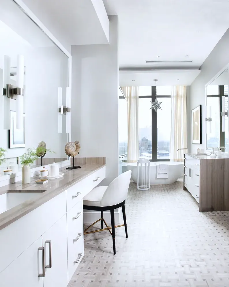 A bathroom with stone surfaces and a frameless shower.
