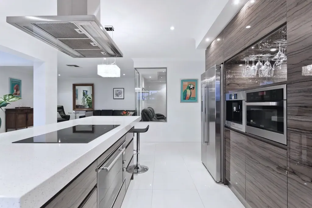 A kitchen with a stone island and integrated appliances.