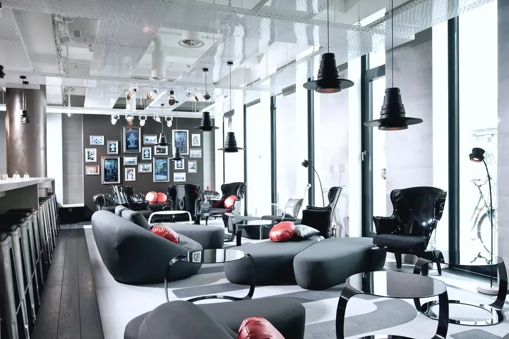 A lounge with low black seating, pendant lamps and floor to ceiling windows