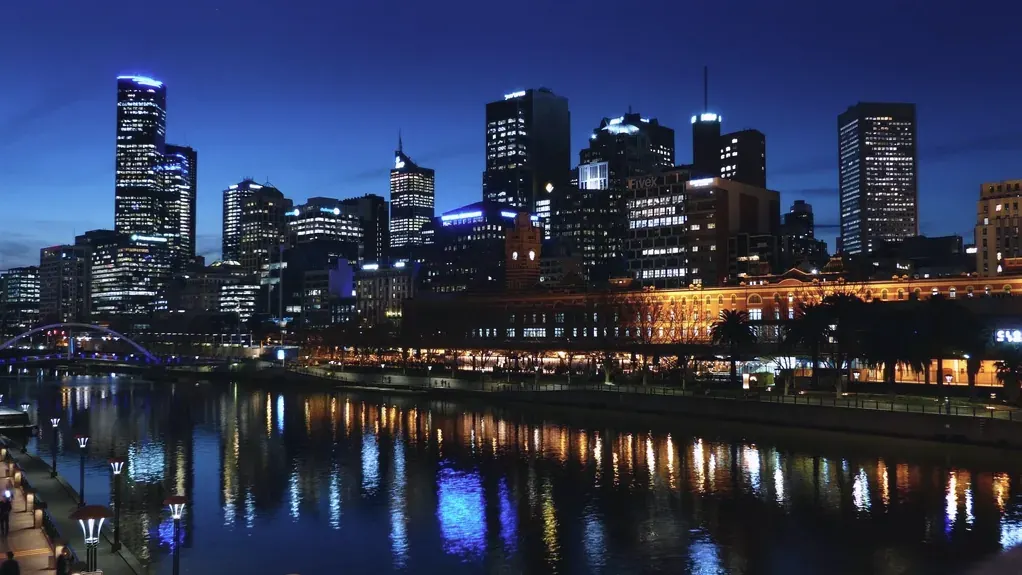 The river at night with the city skyline reflected in the water